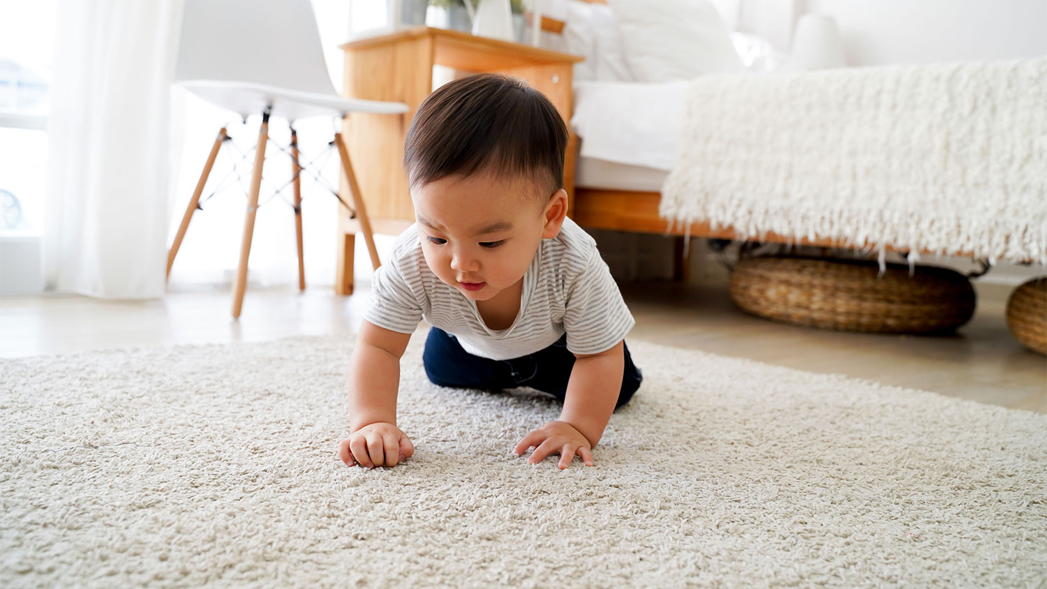 Baby boy crawling on carpet at home