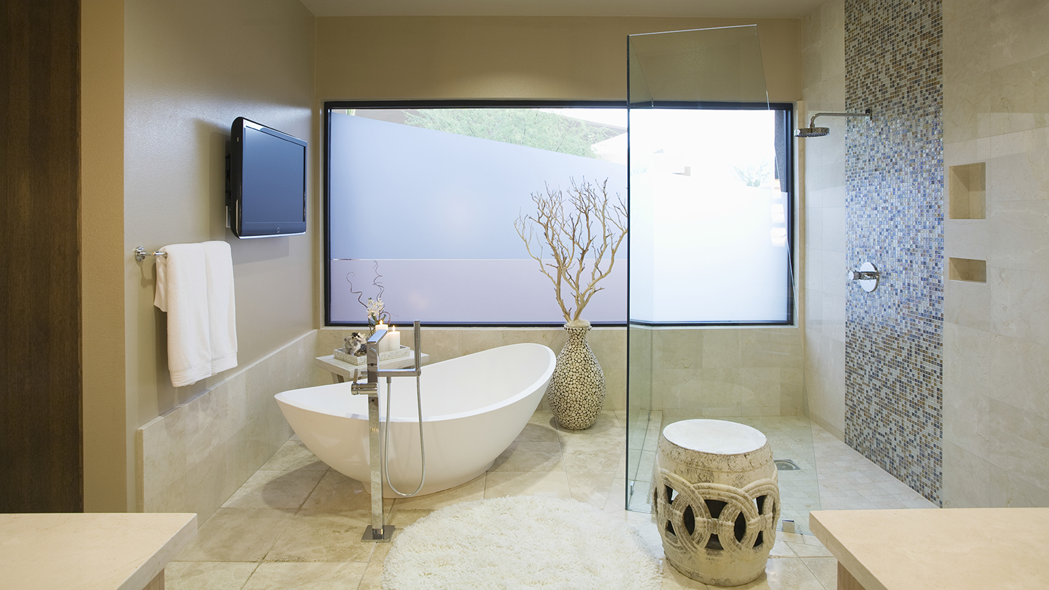 soaking tub in front of bathroom tv  
