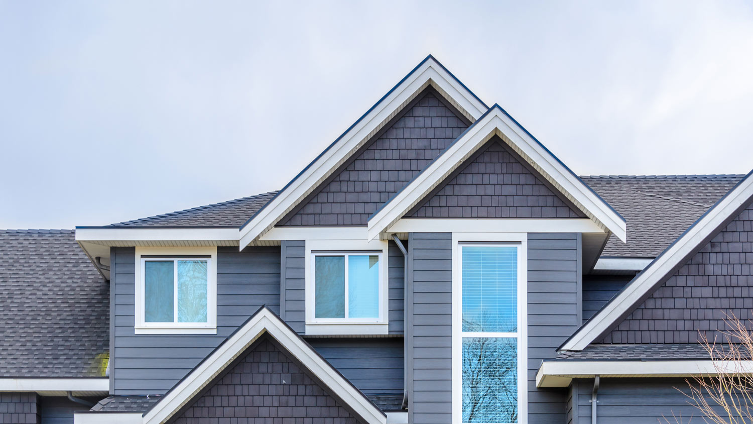The top of a grey house with nice windows