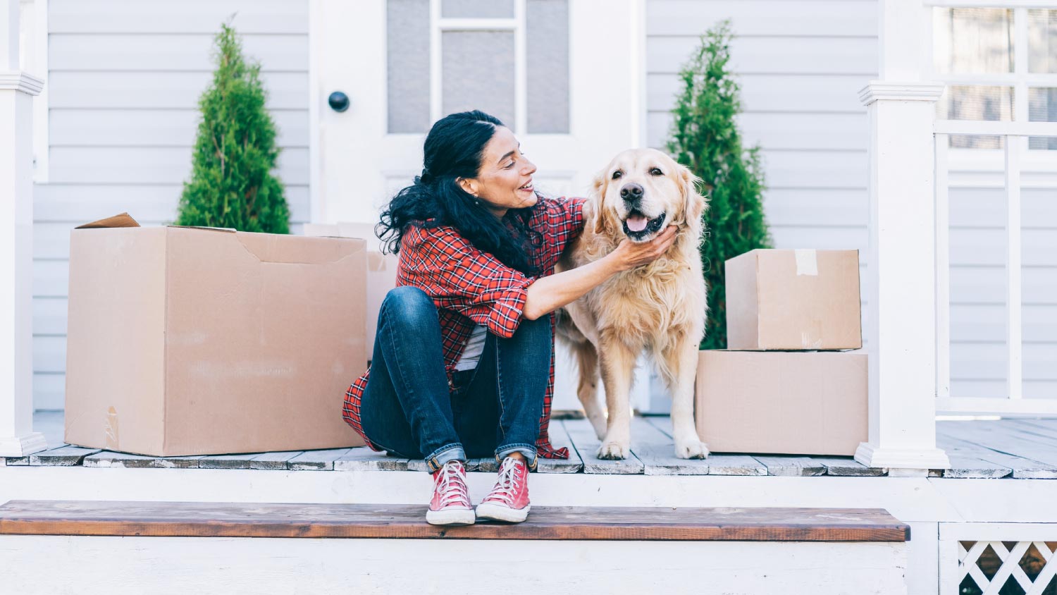 A woman moving to a new house with her dog